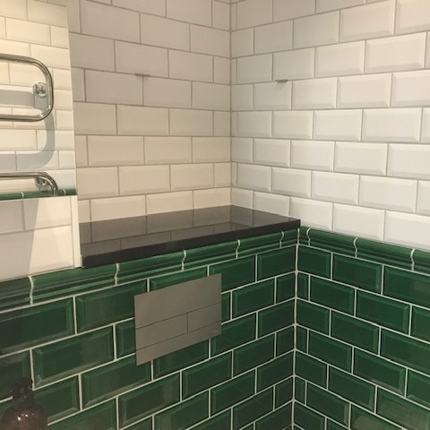 Svart granitsten ovan fixturen för toaletten.