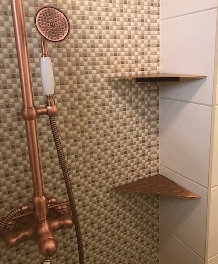 Hyllor i kopparfärg för schampoflaskor